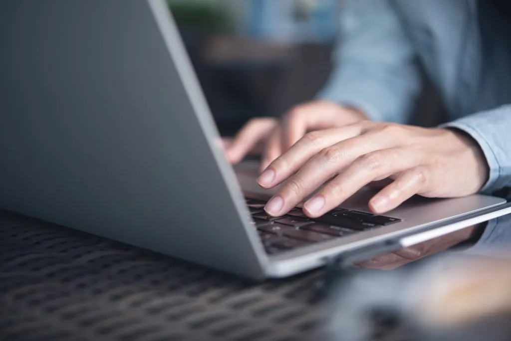 Woman hands typing on laptop computer on table at office. Female worker, freelancer online working from cafe, remotely work Woman hands typing on laptop computer on table at office. Female worker, freelancer online working from cafe, remotely work